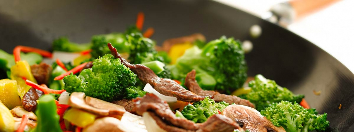 Chicken and vegetable stir fry steaming in a steel wok